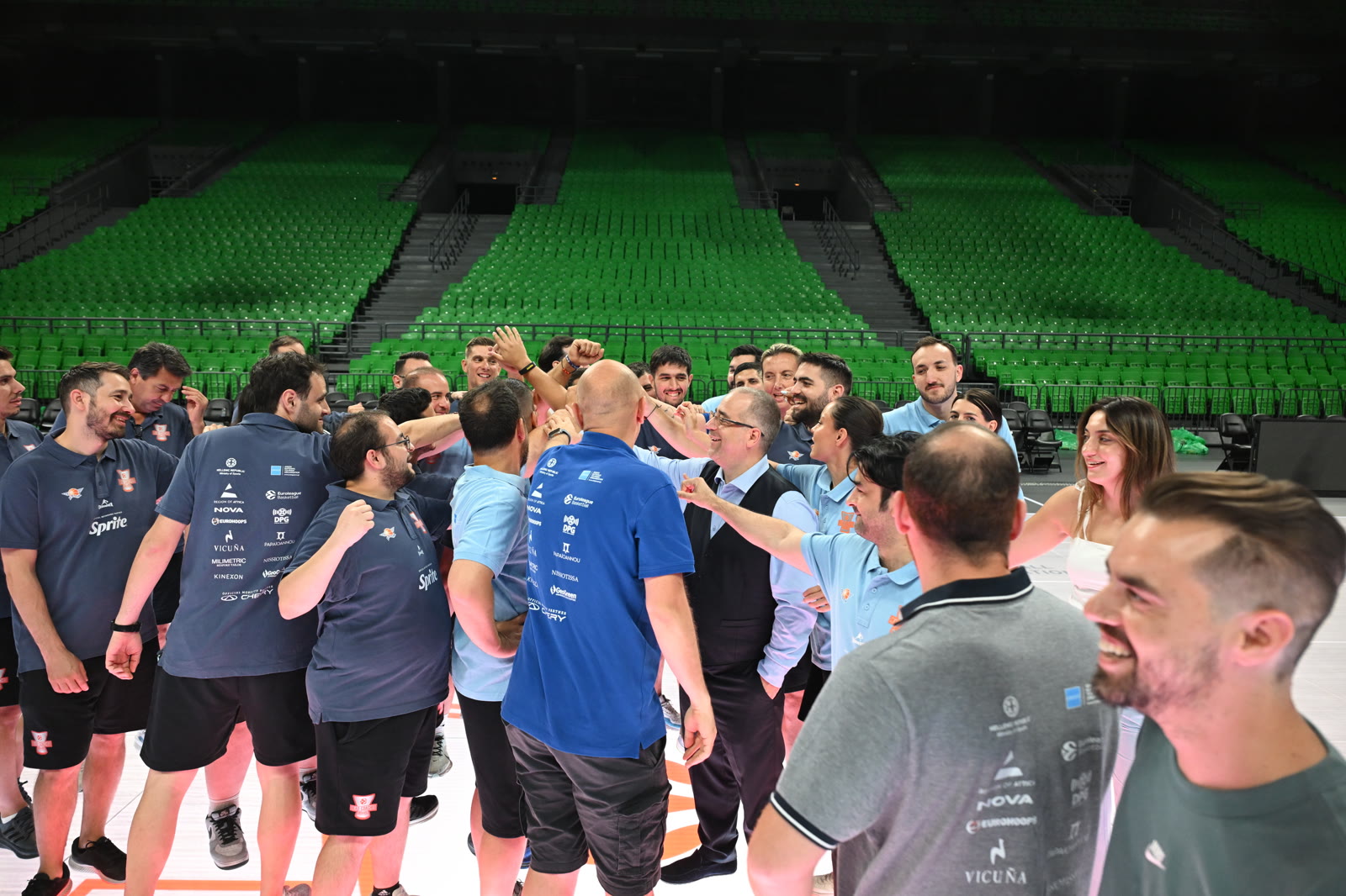 Coaches Academy participants gathering in a courtside huddle